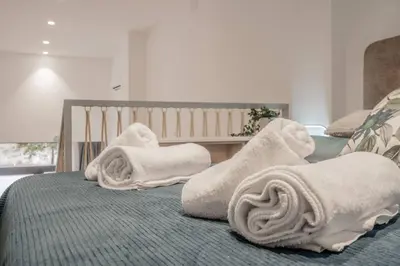 a bed with white towels on top of it at Suite Guillem Jáfer - Roig Arena in Valencia