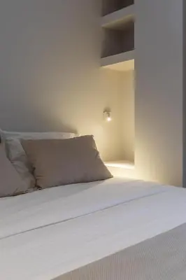a bed with white sheets and pillows in a room at Valencia Malvarrosa point white in Valencia