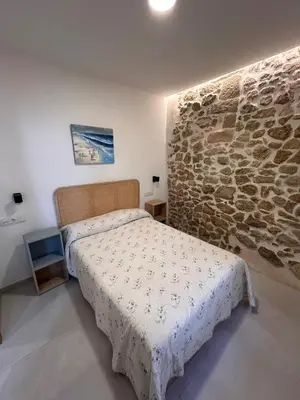 a bedroom with a bed and a stone wall at Apartamento La Fragua - A ESTRENAR - BRAND NEW in Chulilla