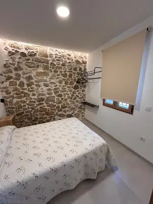 a bedroom with a bed and a stone wall at Apartamento La Fragua - A ESTRENAR - BRAND NEW in Chulilla
