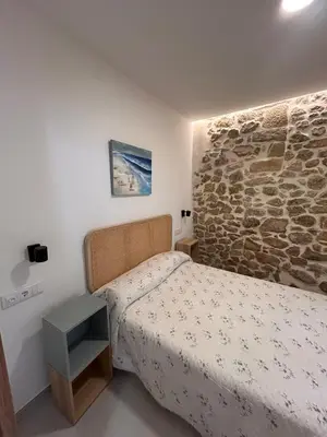 a bedroom with a bed and a stone wall at Apartamento La Fragua - A ESTRENAR - BRAND NEW in Chulilla
