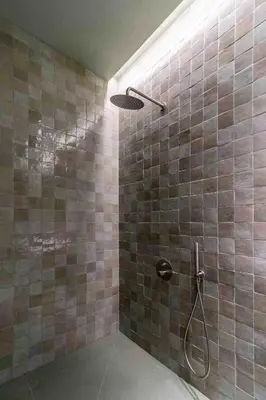 a bathroom with a shower with brown tiles at Valencia Malvarrosa Beach point green in Valencia