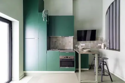 a green kitchen with a table and a refrigerator at Valencia Malvarrosa Beach point green in Valencia