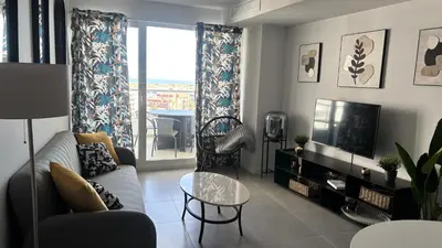 a living room with a couch and a tv at Gran Canet, relax y confort a pocos pasos del mar in Canet de Berenguer