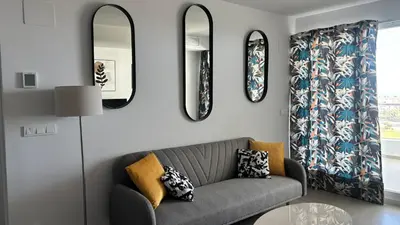 a living room with a couch and two mirrors at Gran Canet, relax y confort a pocos pasos del mar in Canet de Berenguer