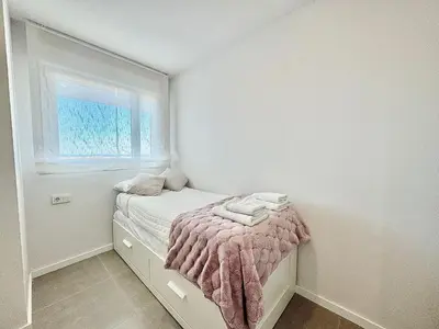 a small bedroom with a bed and a window at Gran Canet, relax y confort a pocos pasos del mar in Canet de Berenguer