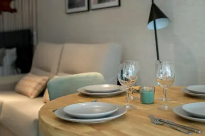 a wooden table with plates and wine glasses on it at District Key - Valencia, O Arocena 1 in Valencia