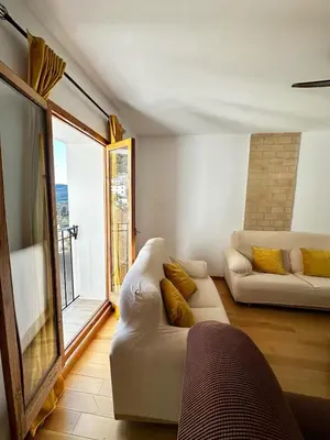 a living room with two white couches and a large window at Casa Durá in Chulilla