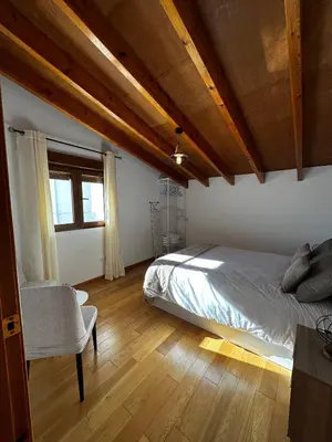 a bedroom with a bed and a chair in it at Casa Durá in Chulilla