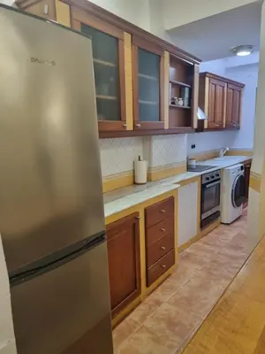 a kitchen with a stainless steel refrigerator and wooden cabinets at Les Dos Nines in Monserrat