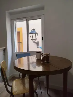 a wooden table and chairs in a room with a window at Apartamento Rústico in Cortez de Pallas