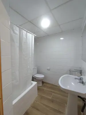 a white bathroom with a toilet and a sink at Apartamento Rústico in Cortez de Pallas