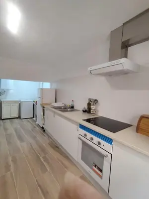 a kitchen with white appliances and a wooden floor at Apartamento Rústico in Cortez de Pallas