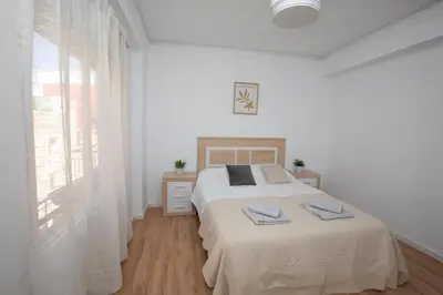 a white bedroom with a bed and a window at Lujoso Apartamento en Valencia 3 Dormitorios con Parking in Paterna