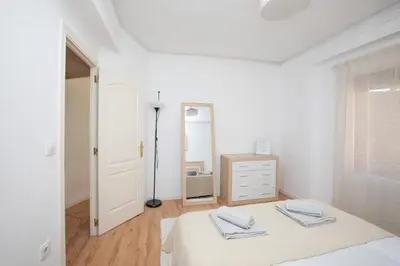 a white bedroom with a bed and a dresser at Lujoso Apartamento en Valencia 3 Dormitorios con Parking in Paterna