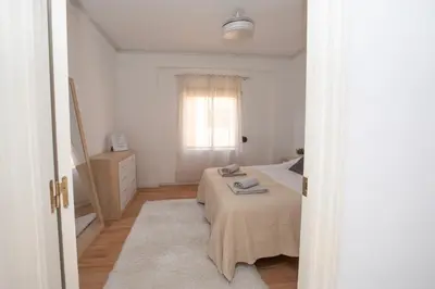 a white bedroom with a bed and a window at Lujoso Apartamento en Valencia 3 Dormitorios con Parking in Paterna