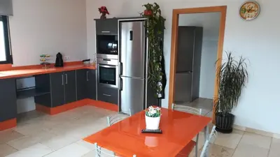 a kitchen with a red table and a refrigerator at La villa de Naomi in Chella