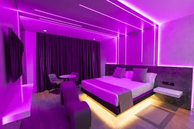 a purple bedroom with a bed and a table at Motel JOC in Valencia
