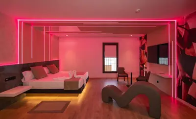a bedroom with a bed and a pink wall at Motel JOC in Valencia