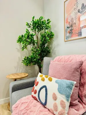 a couch with a pillow and a plant in a room at Bright & Stylish Flat Close To Center in Valencia