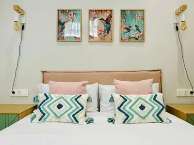 a bedroom with a bed with four paintings on the wall at Bright & Stylish Flat Close To Center in Valencia