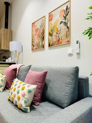 a couch in a living room with paintings on the wall at Cozy & Stylish Loft near City Center in Valencia