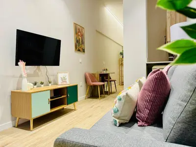 a living room with a couch and a tv at Cozy & Stylish Loft near City Center in Valencia