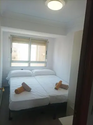 two beds in a small room with a window at El Cabañal 400 meters from the Beach in Valencia