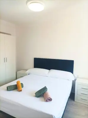 a bedroom with a white bed with two towels on it at El Cabañal 400 meters from the Beach in Valencia