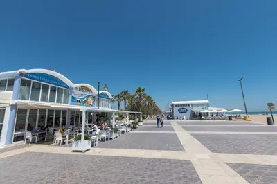 a building with tables and chairs on a street at El Cabañal 400 meters from the Beach in Valencia