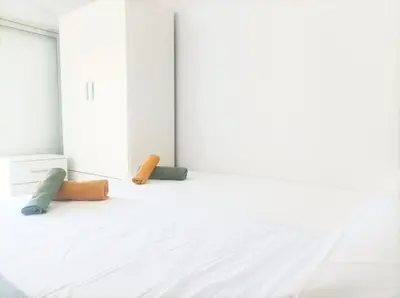 a white room with three pillows on a bed at El Cabañal 400 meters from the Beach in Valencia