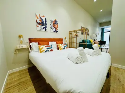 a bedroom with a large bed with white sheets and pillows at Stylish Studio near City Center in Valencia