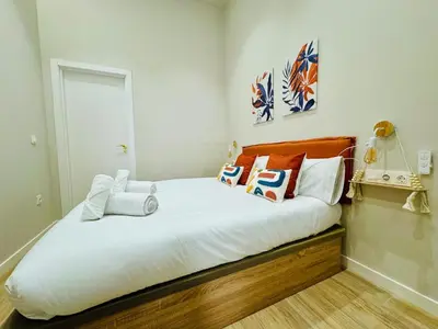a bedroom with a bed with white sheets and pillows at Stylish Studio near City Center in Valencia