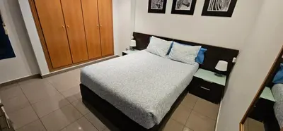 a small bedroom with a bed with blue pillows at Playa La Patacona in Valencia