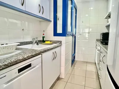 a kitchen with white cabinets and a sink at Playa La Patacona in Valencia