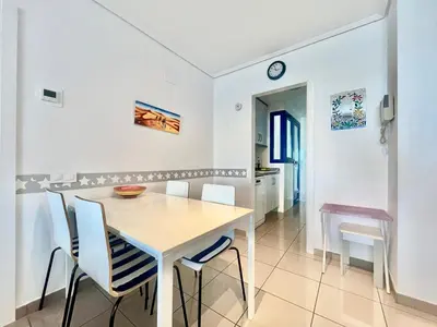 a white dining room with a white table and chairs at Playa La Patacona in Valencia