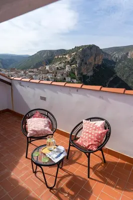 two chairs and a table on a balcony with a view at Miralrio Chulilla in Chulilla
