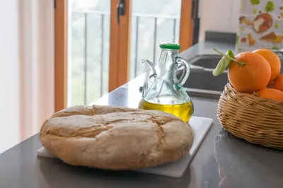 a loaf of bread and a bottle of oil and a basket of oranges at Miralrio Chulilla in Chulilla