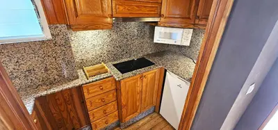 a small kitchen with wooden cabinets and a microwave at Vacansis Atico Loft El Mercat in Valencia