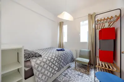 a small bedroom with a bed and a chair at Apartment Ruzafa 4 bedroom in Valencia