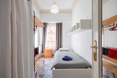 a small bedroom with a bed and a tv at Apartment Ruzafa 4 bedroom in Valencia