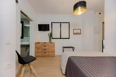 a bedroom with a bed and a black chair at Loft bien equipado - Lavavajillas, tostadora, secador, in Valencia