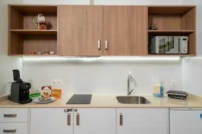 a kitchen with white cabinets and a sink at Loft bien equipado - Lavavajillas, tostadora, secador, in Valencia