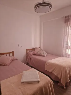 a bedroom with two beds and a light fixture at arena y mar in Tavernes de Valldigna