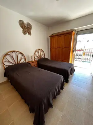 a bedroom with two beds and a butterfly on the wall at Amplio apartamento a 250 metros de la playa in Cullera