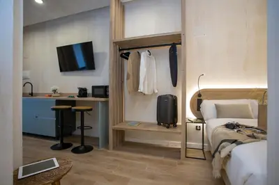 a bedroom with a bed and a desk and a kitchen at Nomad Haux Mestalla Room 101 in Valencia