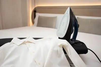 a white shirt and a computer monitor on a bed at Nomad Haux Mestalla Room 101 in Valencia