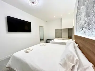 a bedroom with a bed with a tv on the wall at Valencia Getaway - Jacuzzi, Space & Comfort in Valencia