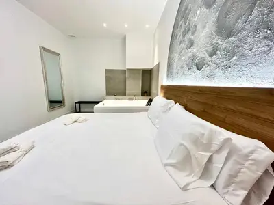 a bedroom with a large white bed and a sink at Valencia Getaway - Jacuzzi, Space & Comfort in Valencia