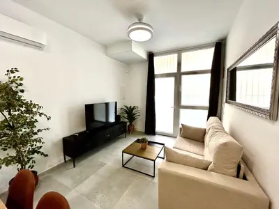 a living room with a couch and a tv at Valencia Getaway - Jacuzzi, Space & Comfort in Valencia